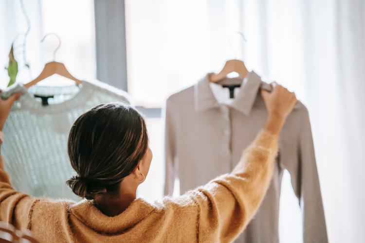 Mujer sosteniendo prendas de ropa