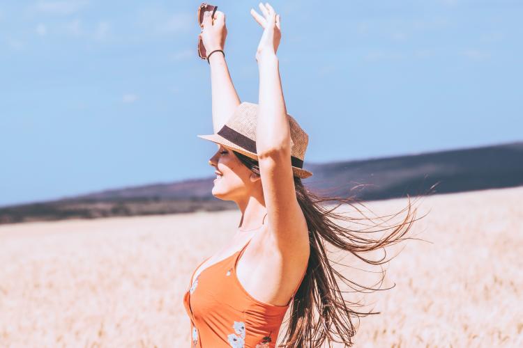 Mujer sonriente alzando los brazos