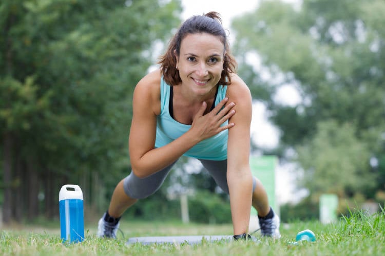 mujer plancha parque Una mujer haciendo el ejercicio de la plancha en un parque