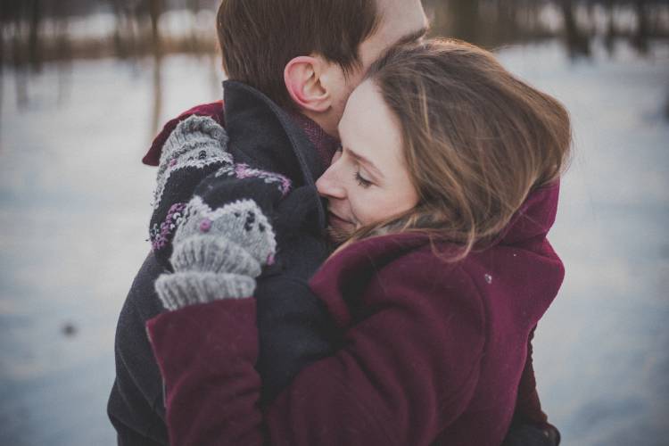 Una pareja se abraza en un lugar frío