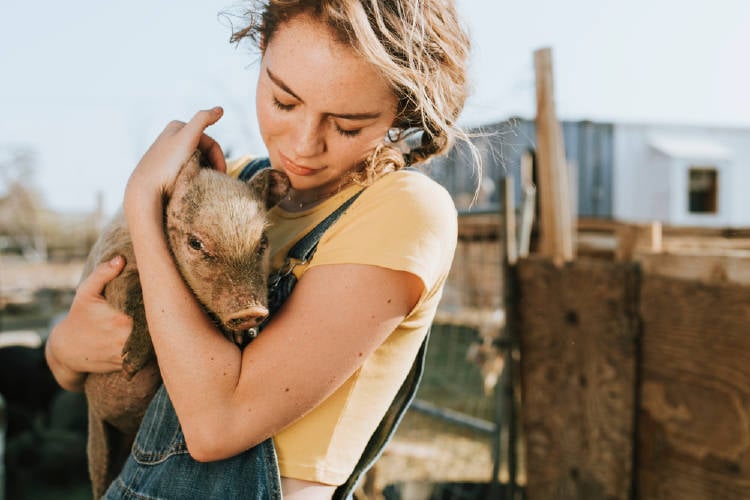 Mujer con chancho en brazos