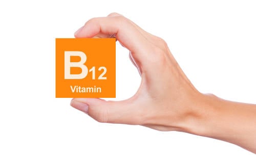 mano sostiene vitamina b12