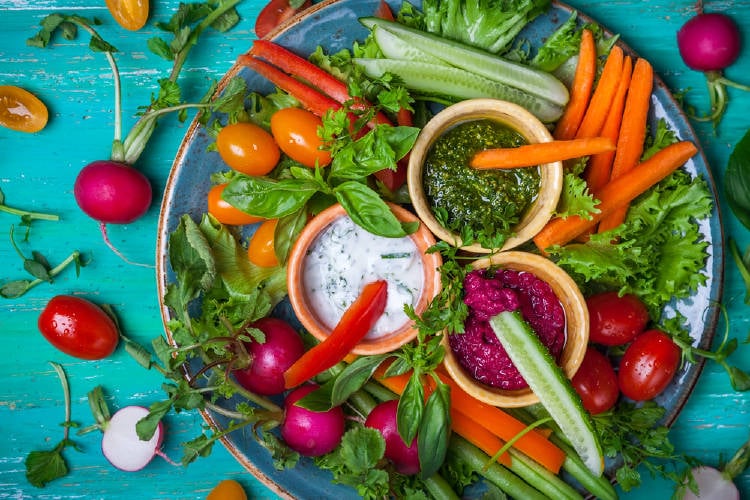 Dips con vegetales alrededor