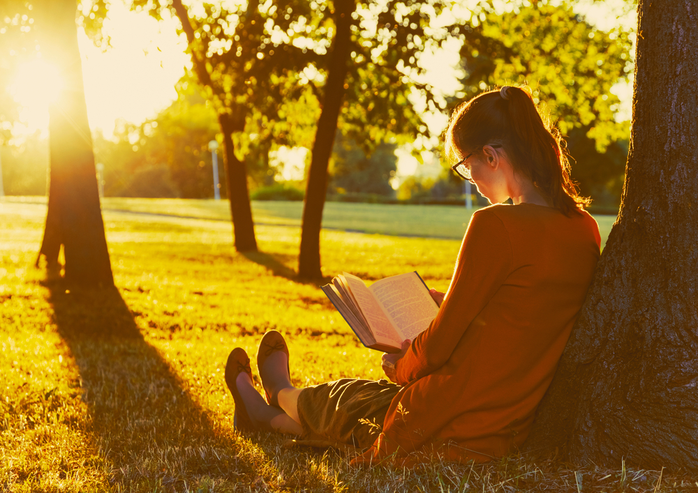 lectura mujer lee apoyada en un arbol
