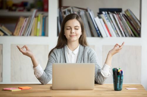 mujer medita y se relaja en frente de computador