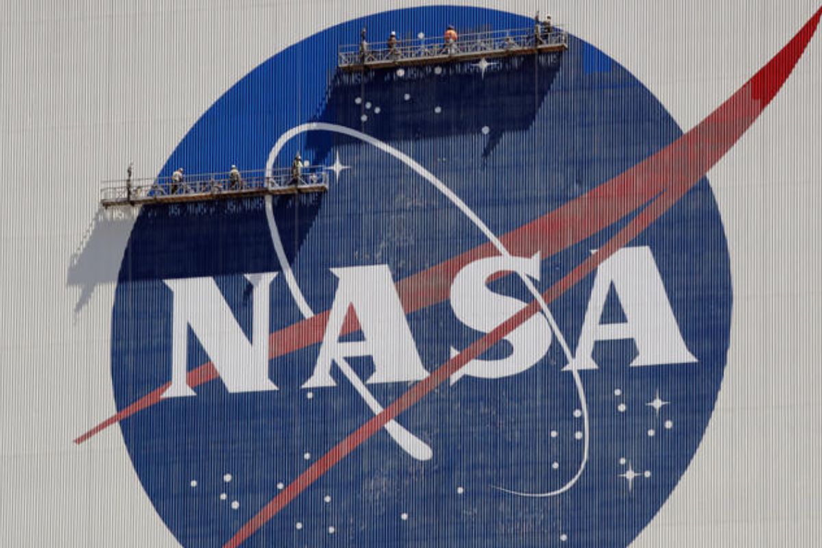 ARCHIVO   trabajadores en andamios repintan el logo de la NASA en el Centro Espacial Kennedy, Cabo Cañaveral, Florida, 20 de mayo de 2020. La NASA dijo el jueves 14 de setiembre de 2023 que el estudio de los OVNI requerirá nuevas técnicas científicas y satélites más avanzados, así como un cambio en la percepción de los objetos voladores no identificados. La agencia espacial dedicó un año al estudio de los OVNI antes de dar a conocer su informe. (AP Photo/John Raoux, File)