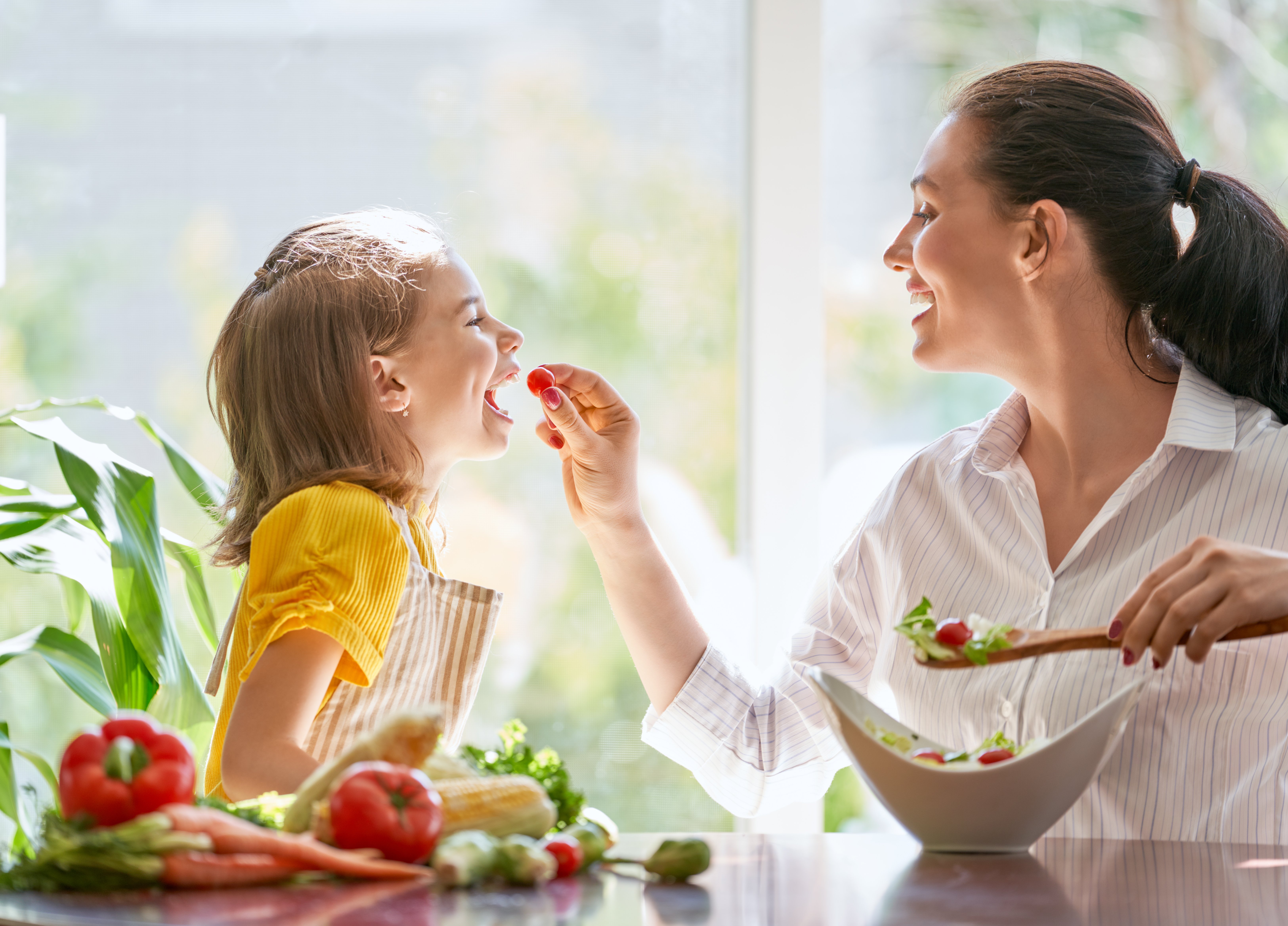 Niña come con su madre