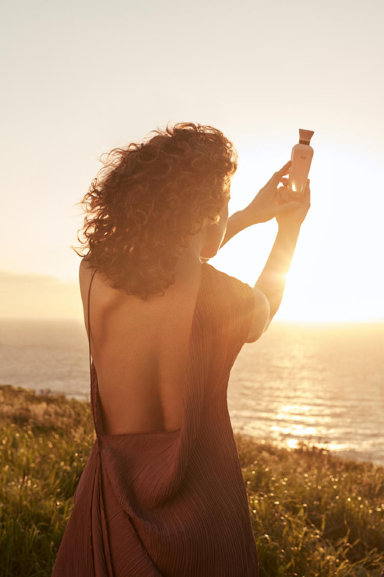 Mujer sosteniendo un perfume