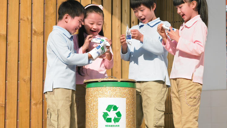 Children handling post consumer cartons