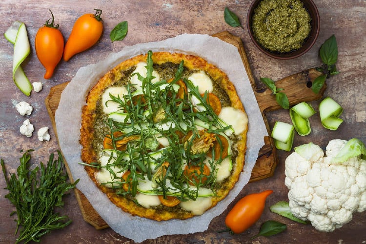 Pizza de coliflor sobre una tabla de madera