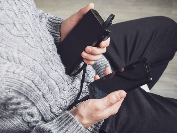 Persona cargando la batería de su teléfono celular con un cargador portátil