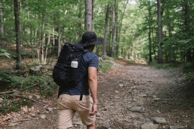 Hombre caminando por el bosque practicando senderismo