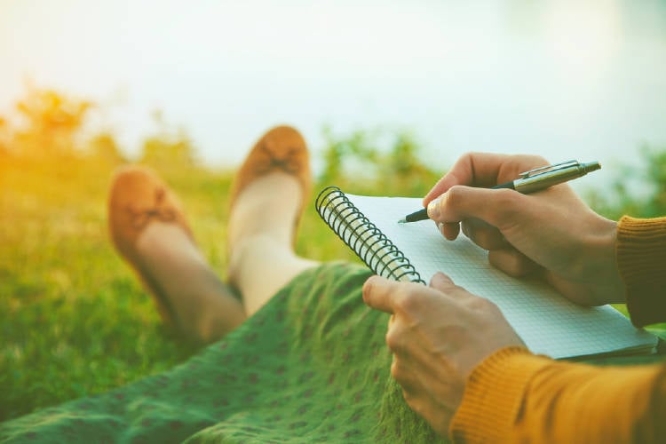 una mujer escribe en un parque