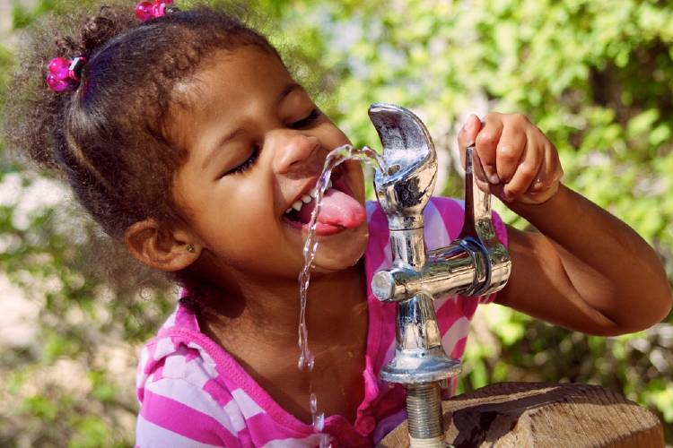 niña bebe agua