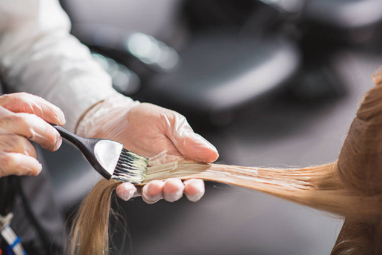 tintura cabello Un hombre le aplica tintura en el cabello a una mujer