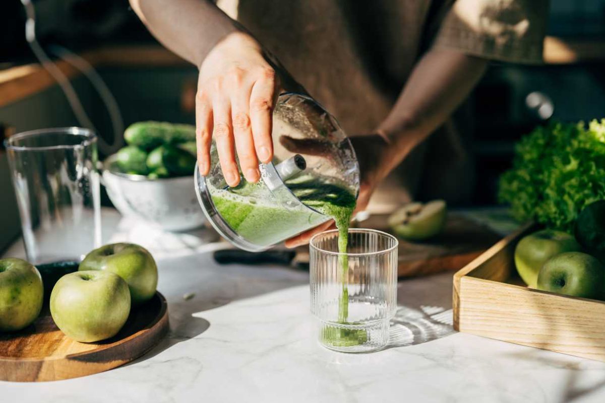 Joven preparando un batido detox en casa. (Fuente de la imagen: Getty Images | Viktoriya Skorikova)
