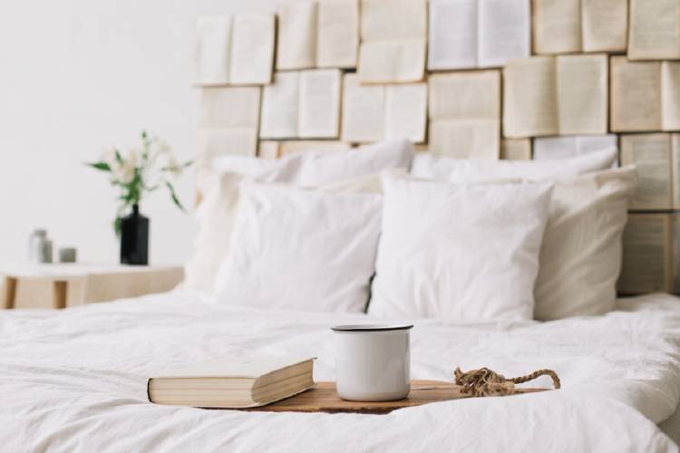 cama con libro y taza de cafe