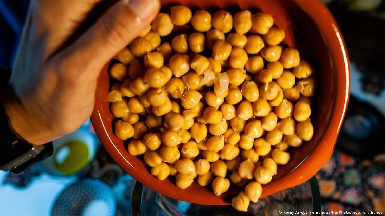 Mano que sostiene una cazuela con garbanzos