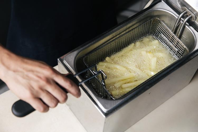 Persona cocinando papas fritas