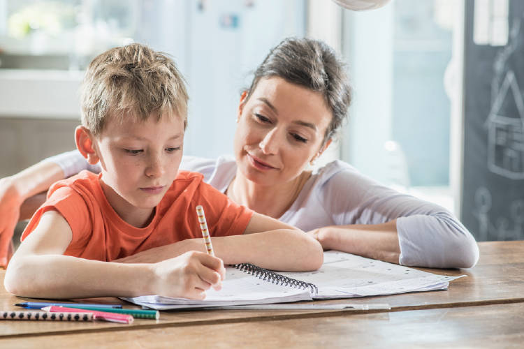 Un niño hace la tarea con su madre