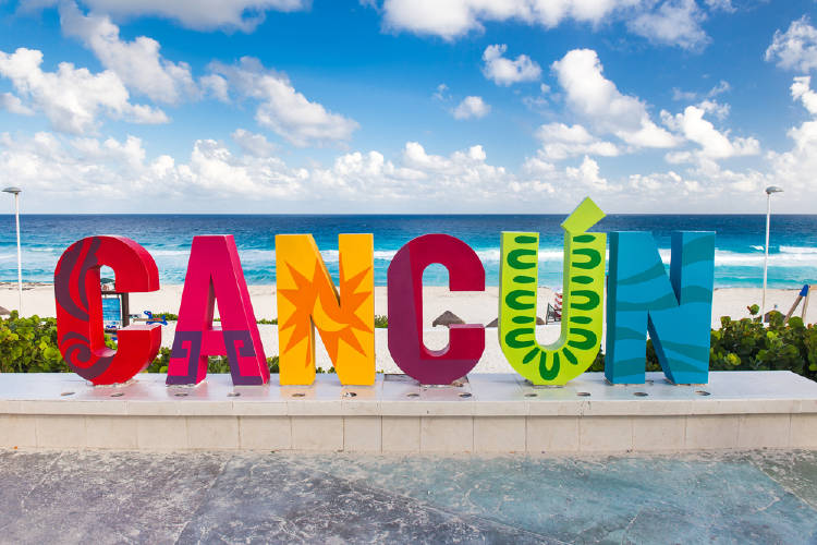 ¡Viajar después de la pandemia con poco dinero es posible! 3 letrero de cancún con cielo lleno de nubes