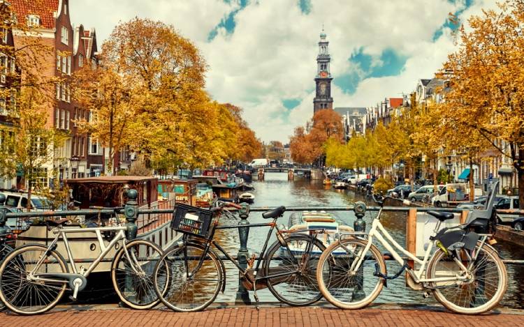 Fotografía de Amsterdam, con bicicletas apoyadas sobre el puente de un canal