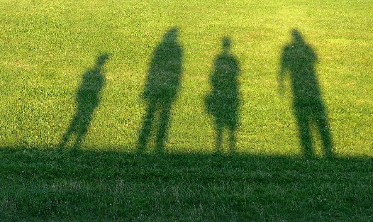 sombras de personas en pasto y sol