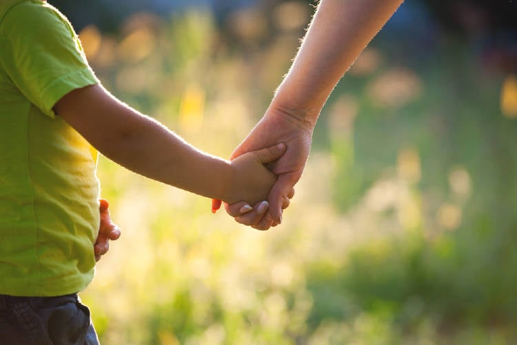 Una madre de la mano con su hijo