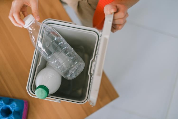 Persona reciclando botellas plástico