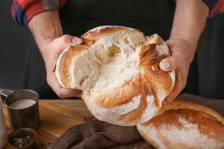 mujer corta pan con la mano pan casero