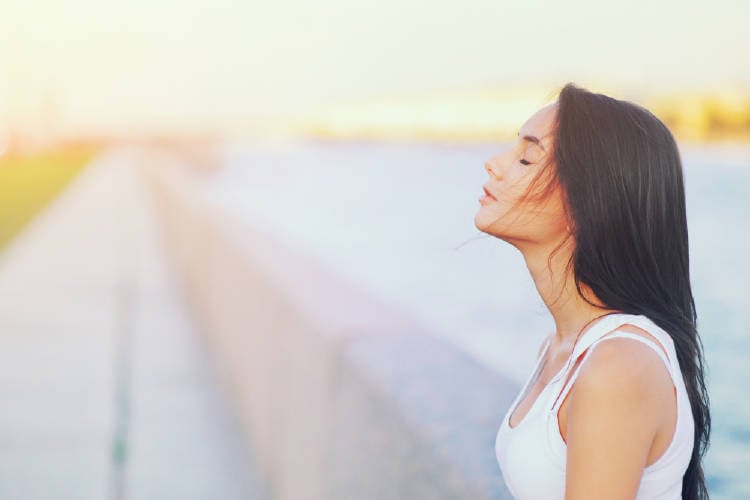 mujer respira aire fresco en la naturaleza y libera el estrés