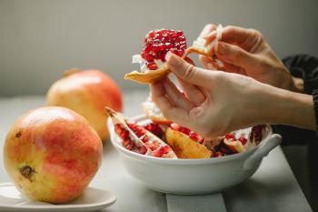 Persona quitando cáscara a una granada fruta