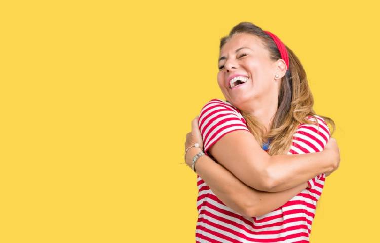 amor propio Una mujer se abraza a sí misma y sonríe