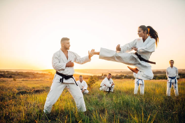 mujer y hombre practican taekwondo en la naturaleza