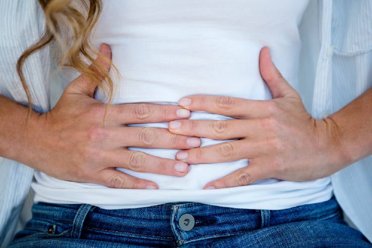 Una mujer se toma la barriga hinchada