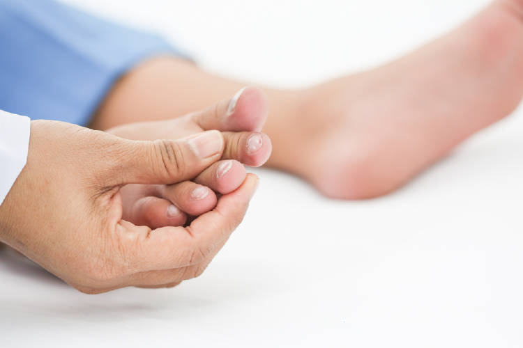 Una persona examinando las uñas de sus pies