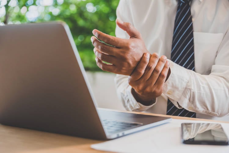 dolor de muñecas hombre con dolor de muñecas a causa del trabajo en la computadora