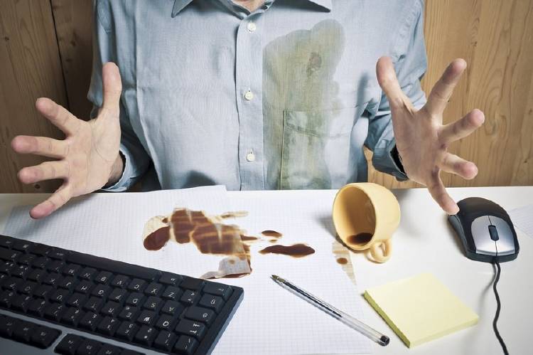 Un hombre se mancha la camisa con café