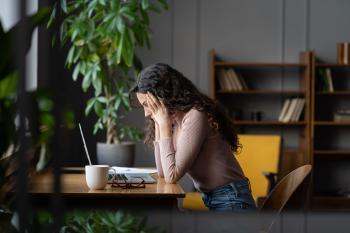 Mujer no para de pensar frente al escritorio