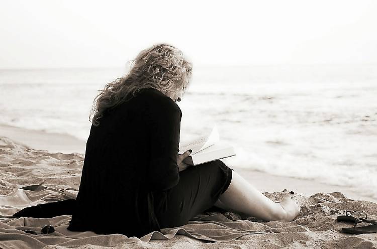 Mujer leyendo en la playa