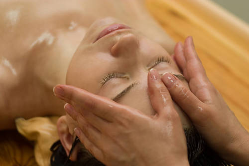 mujer recibe un masaje aturveda sobre tu frente con aceites esenciales