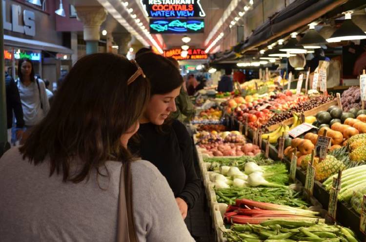 mercado dos mujeres mirando verduras