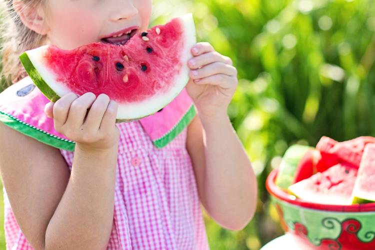 Una niña comiendo sandía